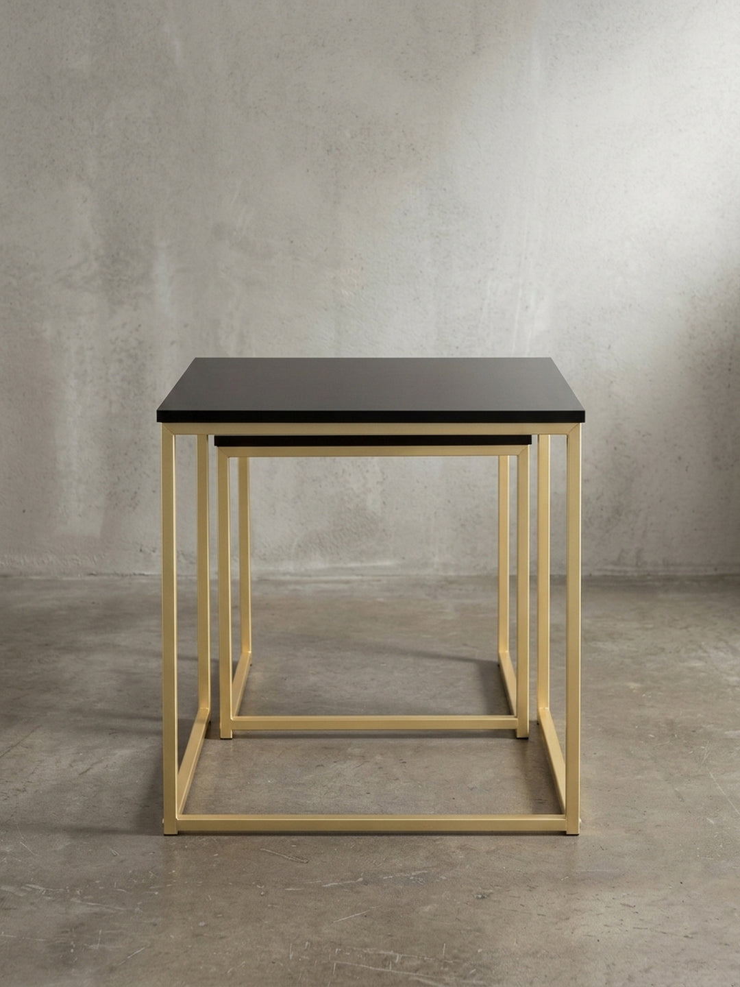Das zweiteilige Couchtisch Set aus lackiertem Metall und MDF in seitlicher Perspektive zeigt die puristische Form und die smarte platzsparende Konstruktion._
