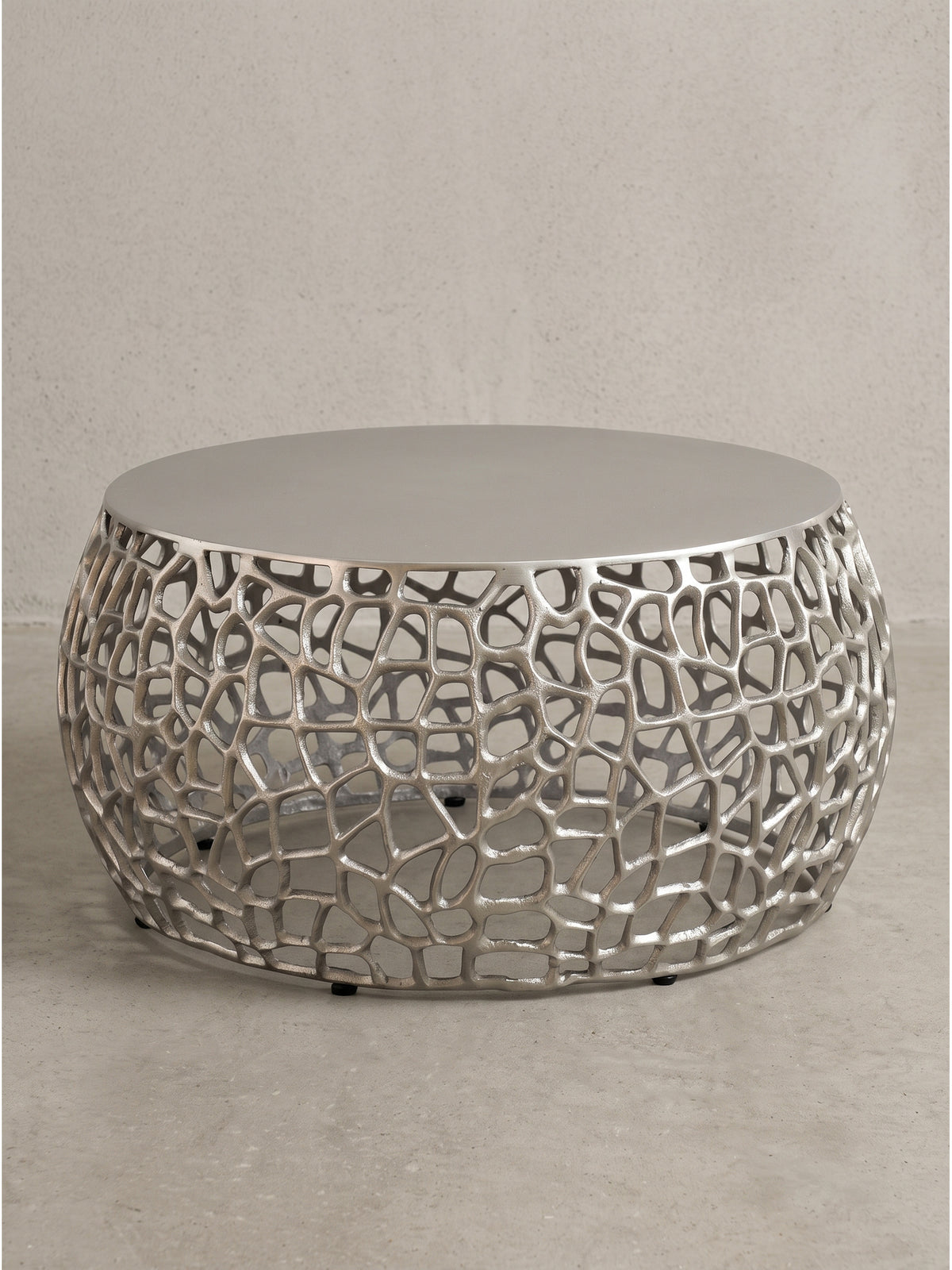 Runder Couchtisch aus Aluminium mit silberner Lackierung und netzartiger Struktur freigestellt auf weißem Hintergrund_