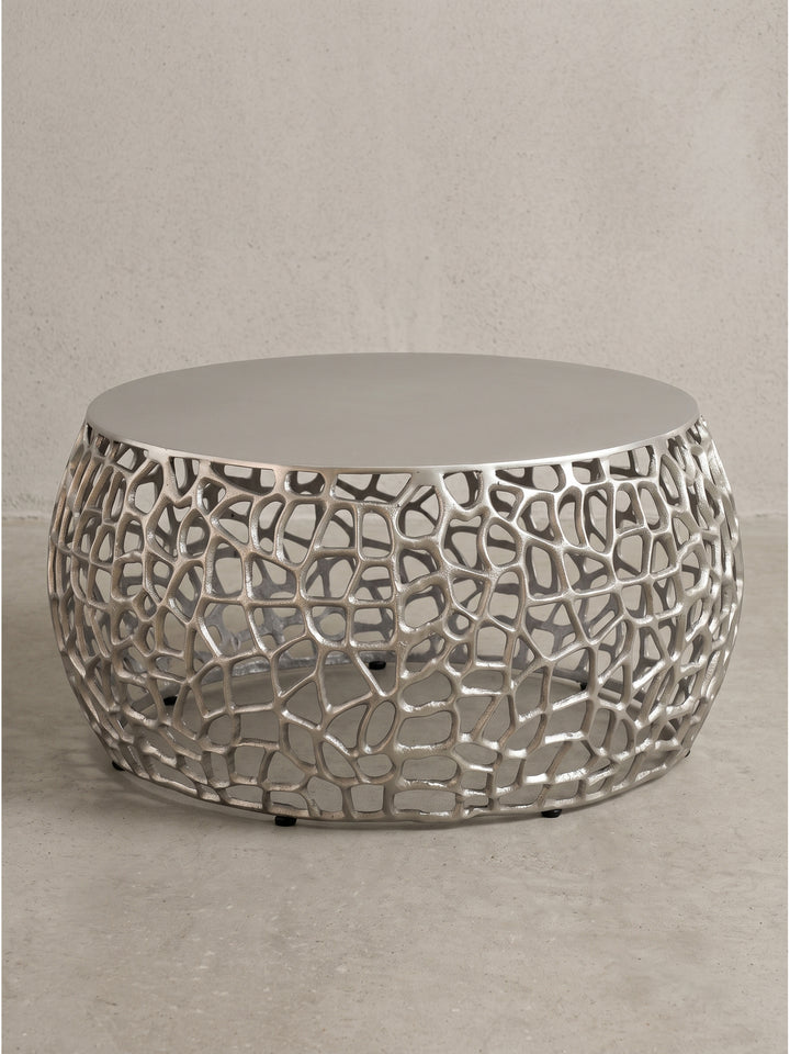 Runder Couchtisch aus Aluminium mit silberner Lackierung und netzartiger Struktur freigestellt auf weißem Hintergrund_