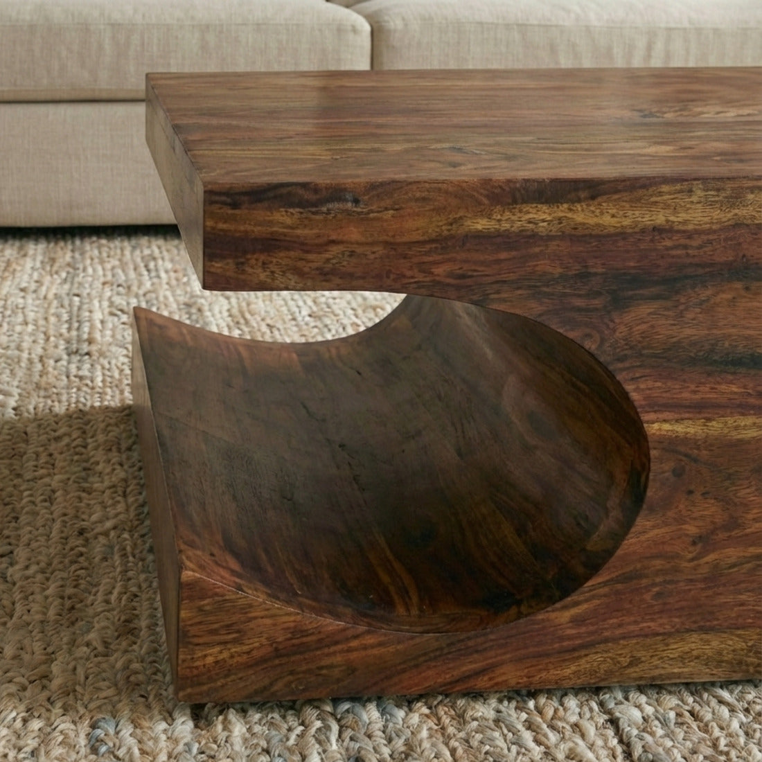 Seitliche Ansicht des Couchtischs TEKO mit rundem, geschwungenem Ablagefach. 