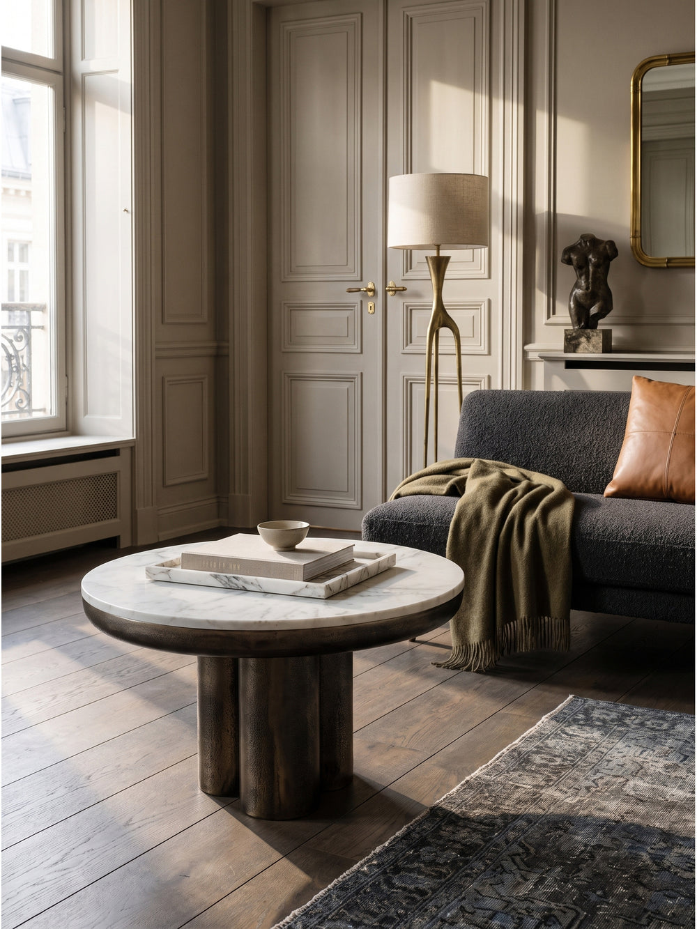 Opulenter Couchtisch aus echtem weißen Marmor mit bronzefarbenem Säulengestell im eleganten Wohnzimmer auf Perserteppich_
