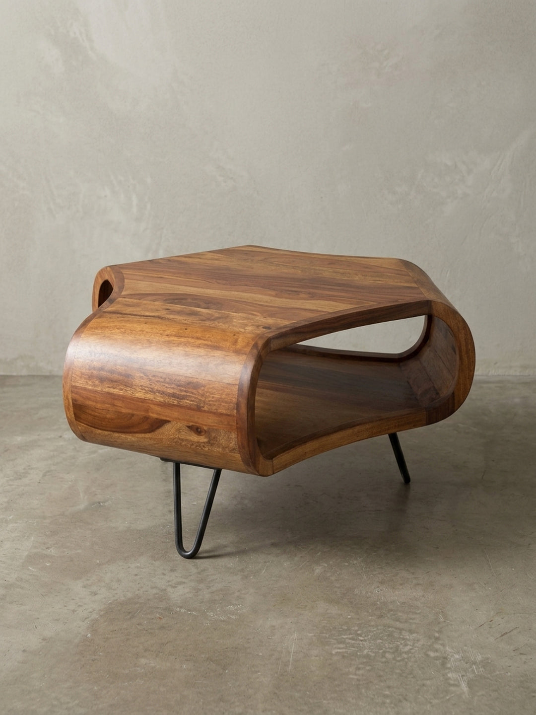 Alternative Perspektive des braunen Wohnzimmertisches, welche die asymmetrische, fließende Form des 55x55cm großen Möbelstücks aus edlem ostindischem Rosenholz gekonnt in Szene setzt._