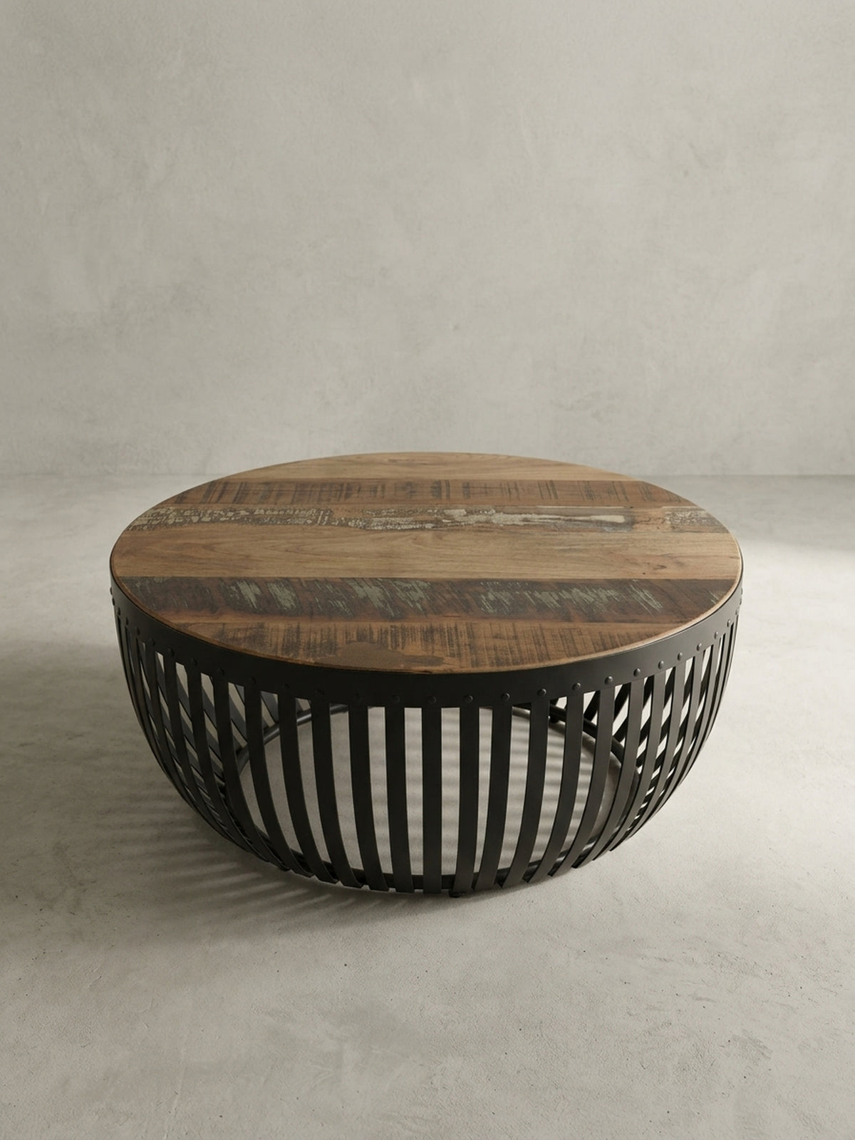 Alternative Perspektive des runden Massivholz-Couchtisches. Das offene Metalldesign erzeugt spannende Schattenspiele und integriert sich perfekt in warme, erdige Wohnzimmer-Einrichtungen._