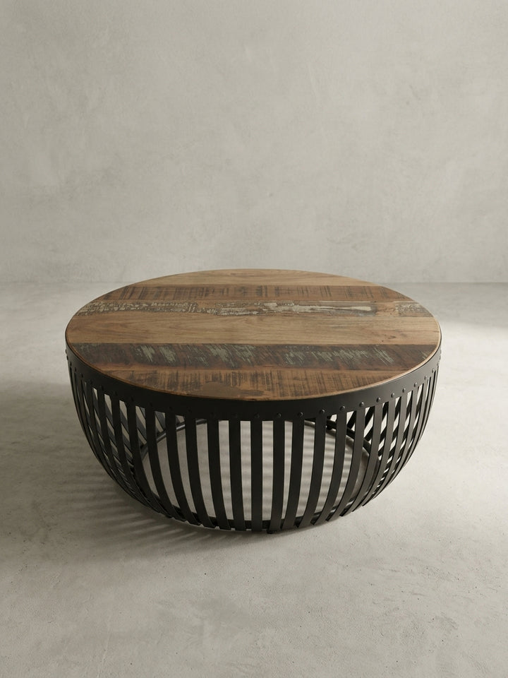 Alternative Perspektive des runden Massivholz-Couchtisches. Das offene Metalldesign erzeugt spannende Schattenspiele und integriert sich perfekt in warme, erdige Wohnzimmer-Einrichtungen._