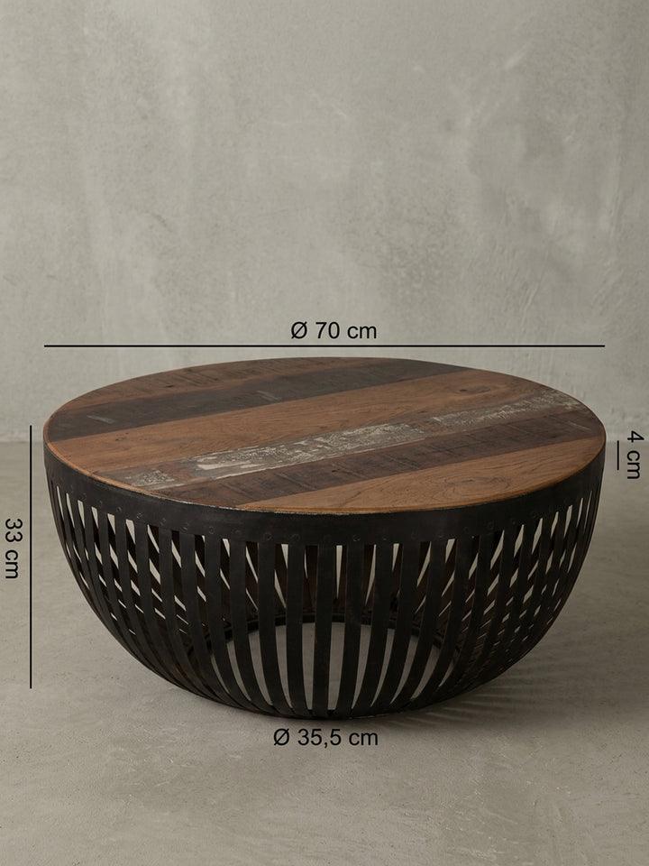 Rückseitige Detailansicht des runden Wohnzimmertisches. Präzise verarbeitete Eisenstreben stützen die rustikale Platte aus recyceltem Holz in einem modernen, bodennahen Clubtisch-Design._