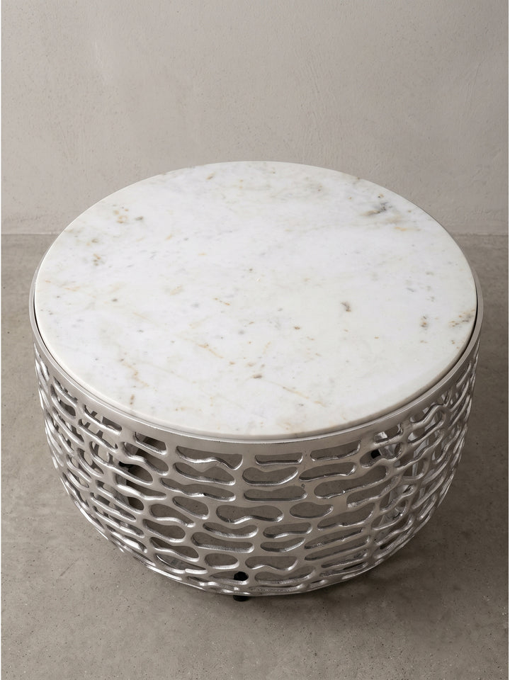Runder Aluminium Wohnzimmertisch Modern mit durchbrochenem silbernem Gestell und Marmortop in seitlicher Perspektive_