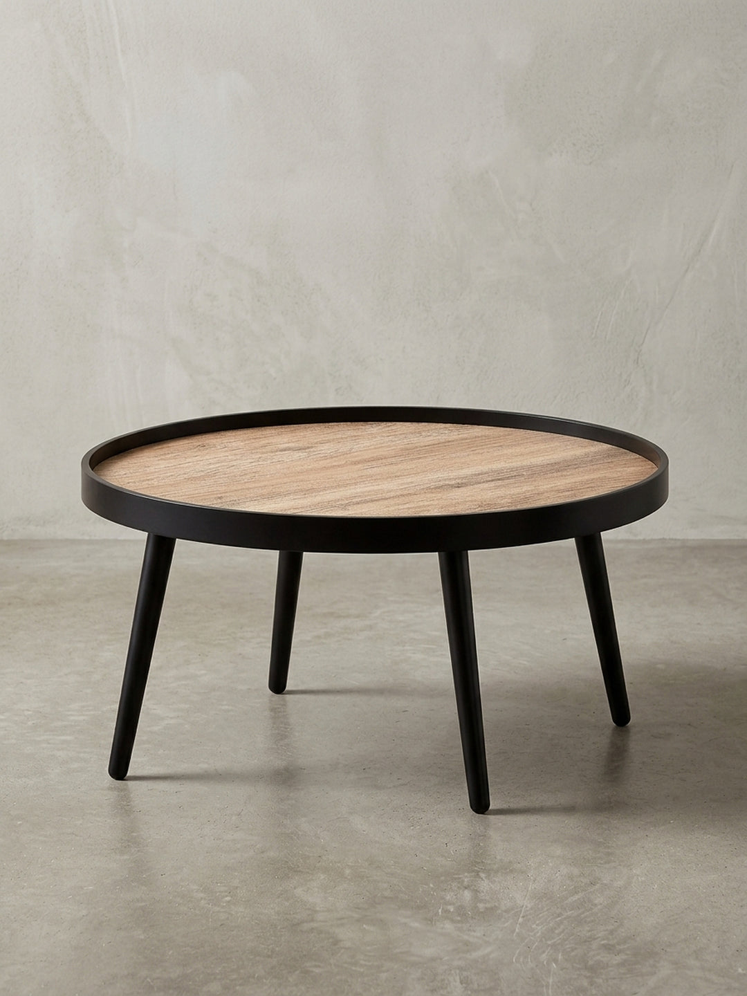 Moderner Couchtisch rund 76 cm Durchmesser, freigestellt mit brauner Tischplatte im Holzlook und mattschwarzen Beinen aus Massivholz._