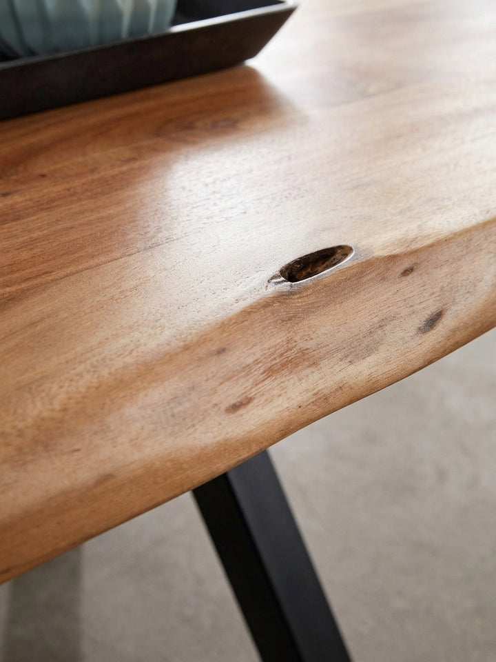 Detailaufnahme des eckigen Couchtisches, die den nahtlosen Übergang von der glatten Oberfläche zur rustikalen Baumkante und die Handwerkskunst des Unikats zeigt._