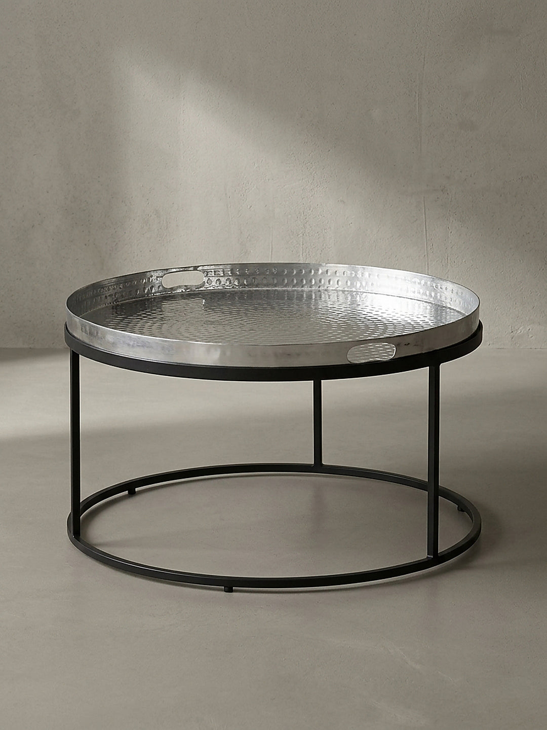 Makroaufnahme des 4 cm hohen Rands vom abnehmbaren Aluminiumtablett des runden Couchtisches im klaren Licht._