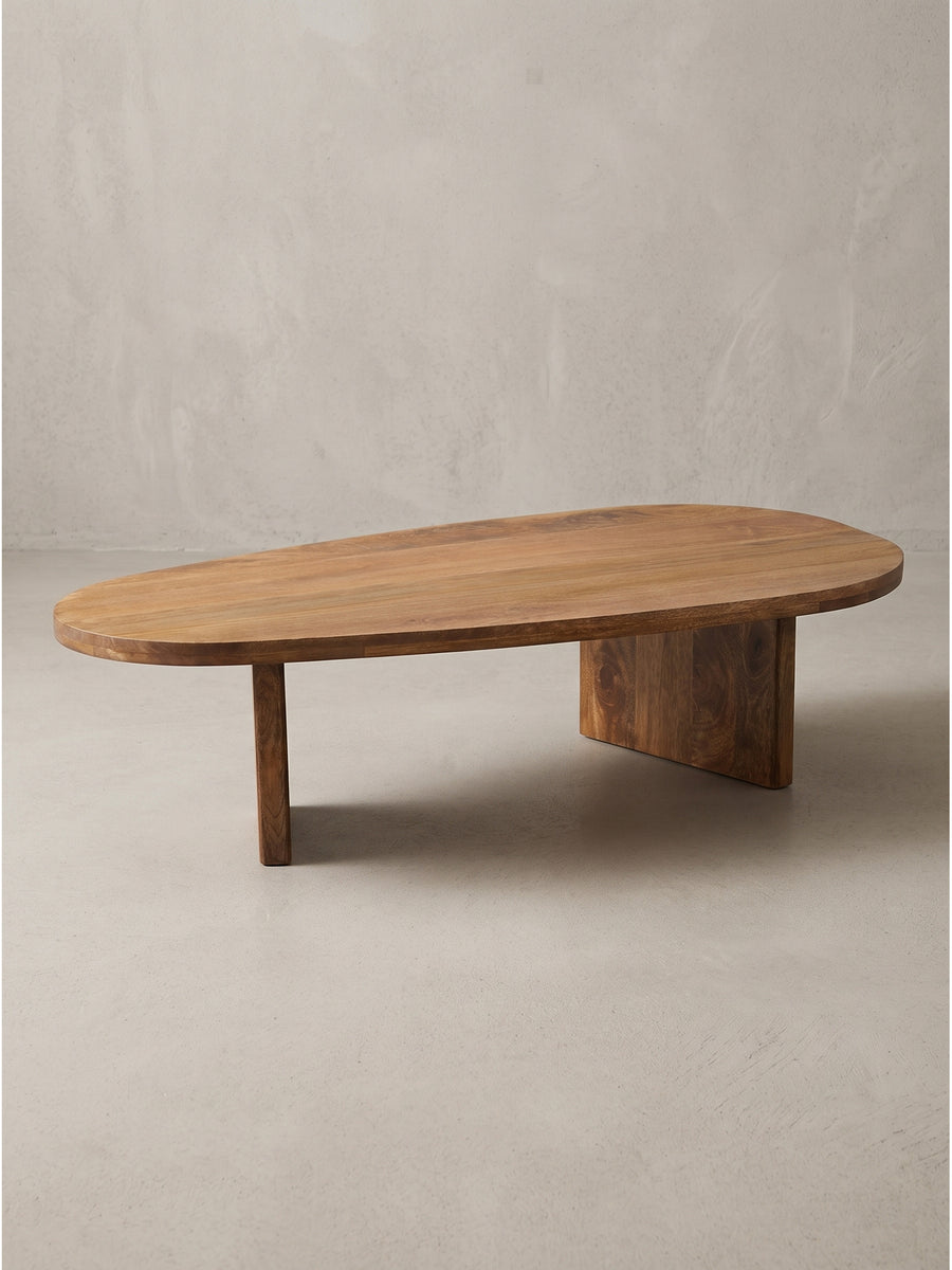 Organisch geformter Couchtisch aus Mango Massivholz freigestellt vor weißem Hintergrund mit klar erkennbarem asymmetrischem Beingestell._