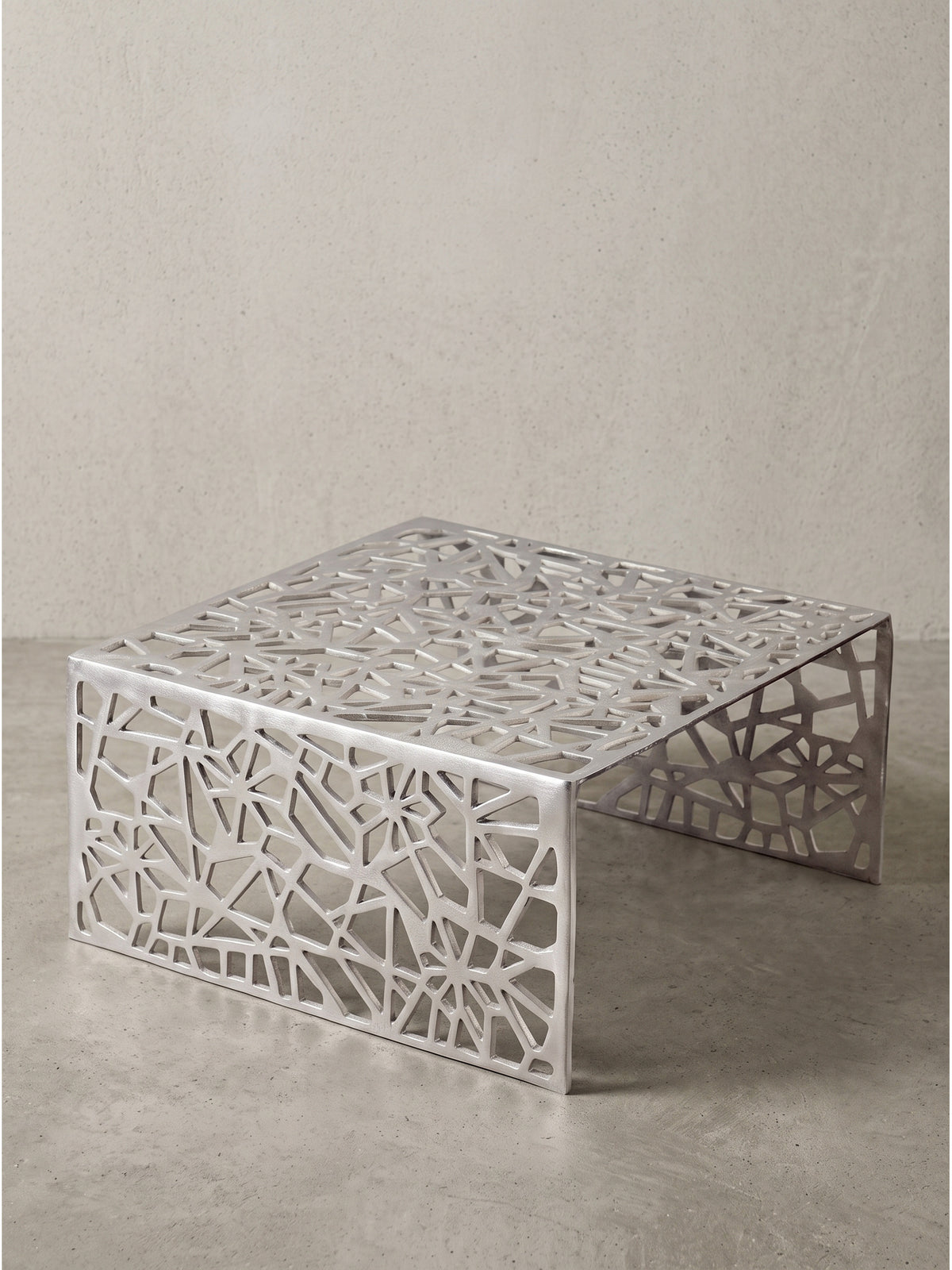 Silberner Couchtisch aus hochwertigem Aluminium 60x60x31 cm in leicht erhöhter Frontalansicht mit filigranem Cut-Out-Design_