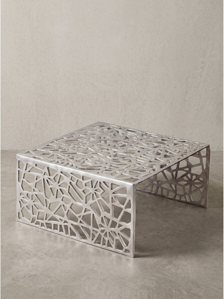 Silberner Couchtisch aus hochwertigem Aluminium 60x60x31 cm in leicht erhöhter Frontalansicht mit filigranem Cut-Out-Design_