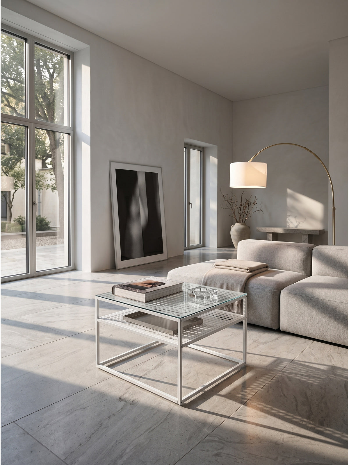 Minimalistischer Couchtisch aus Klarglas und weißem Metallgestell 60x60 cm im puristischen Wohnzimmer auf kühlem Kalksteinboden._