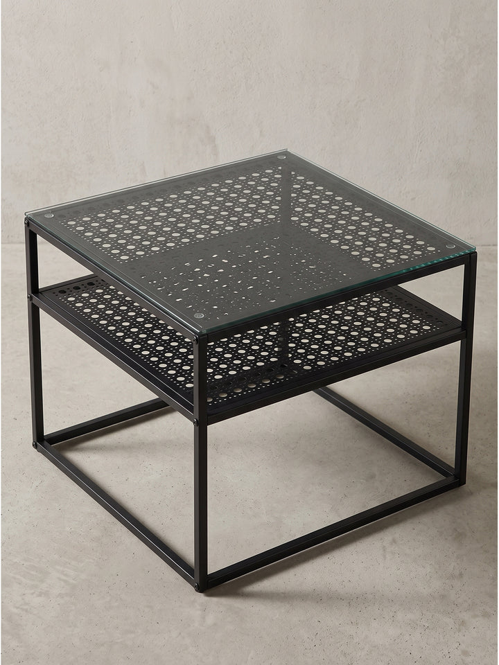 Seitenansicht des modernen Couchtisches mit schwarzem Metallgestell und transparenter Sicherheitsglasplatte_