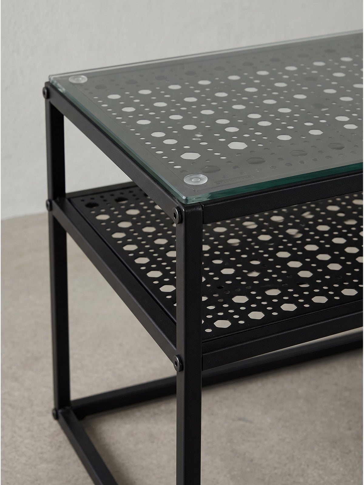 Couchtisch im Loft-Stil mit Glasplatte und Metallgitter aus erhöhter Perspektive komplett freigestellt