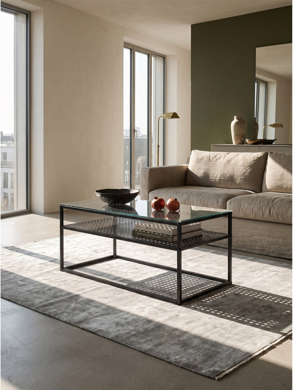 Moderner Couchtisch aus Glas und schwarzem Metall 100x50x45 cm zentral platziert im Wohnzimmer vor einer dunkelgrünen Akzentwand