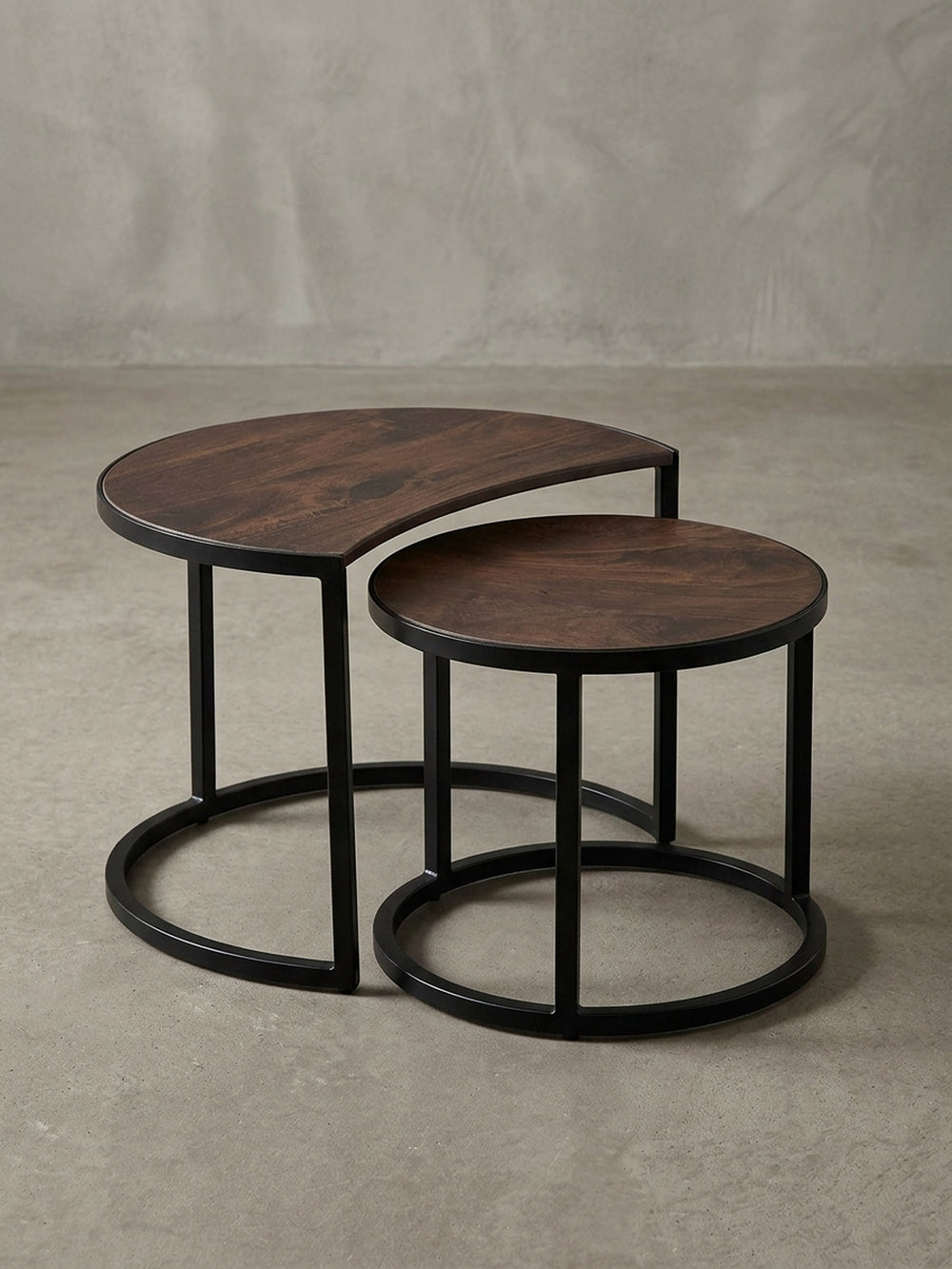 Detailaufnahme des runden Couchtisch-Sets, die die glatte, lackierte Oberfläche des Mangoholzes und das pulverbeschichtete, schwarze Eisengestell zeigt._