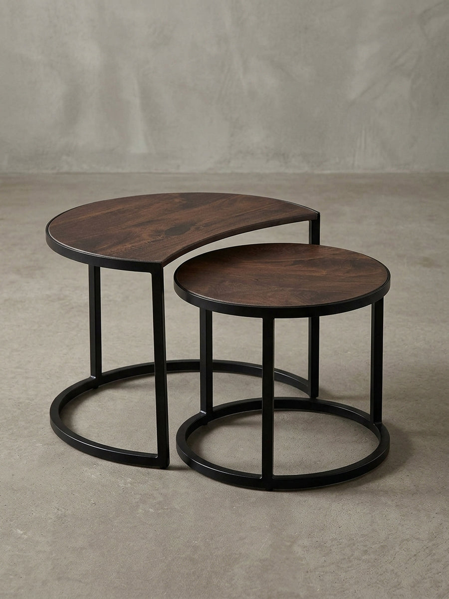 Detailaufnahme des runden Couchtisch-Sets, die die glatte, lackierte Oberfläche des Mangoholzes und das pulverbeschichtete, schwarze Eisengestell zeigt._