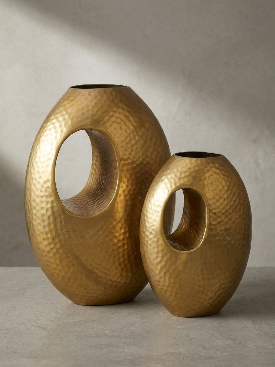Alternative Perspektive auf das goldene Vasen-Set, die das Zusammenspiel von Licht und Schatten auf der gehämmerten Oberfläche einfängt._