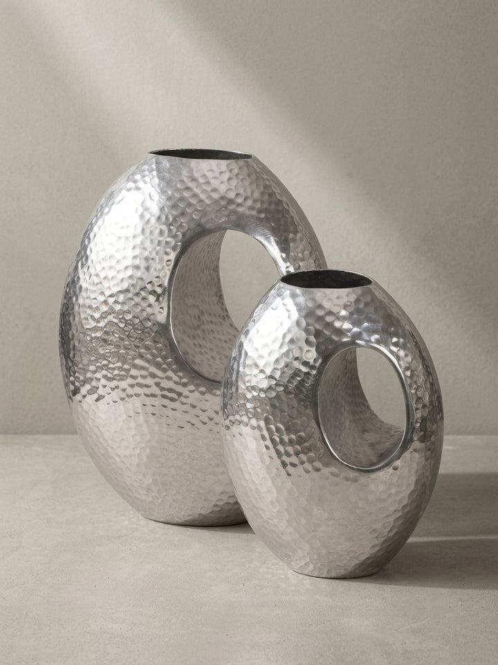 Nahaufnahme der runden Öffnung und des handgefertigten Randes der eleganten Aluminium-Bodenvase in Silber-Optik._