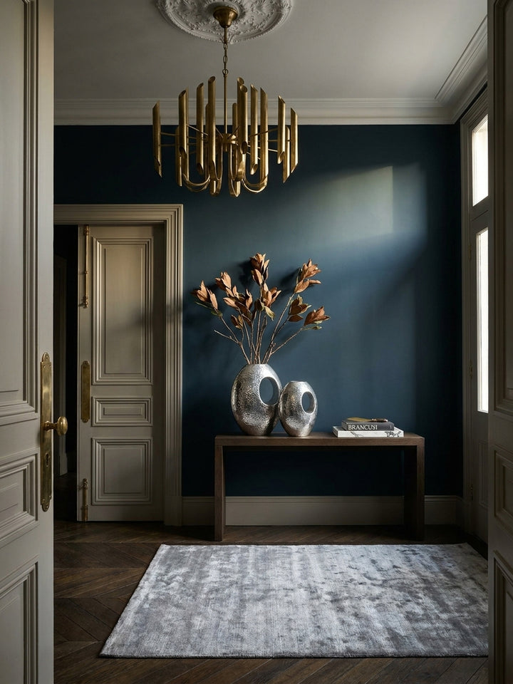 Zwei silberne Aluminiumvasen im Hammerschlag-Design als eleganter Blickfang auf einer Konsole im modern-klassischen Wohnzimmer._