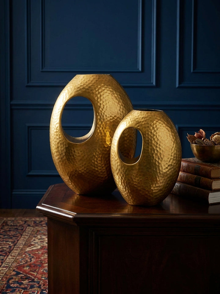 Makroaufnahme der goldenen Oberfläche einer Aluminiumvase, die die detaillierte, unregelmäßige Hammerschlag-Textur und die handwerkliche Qualität zeigt._