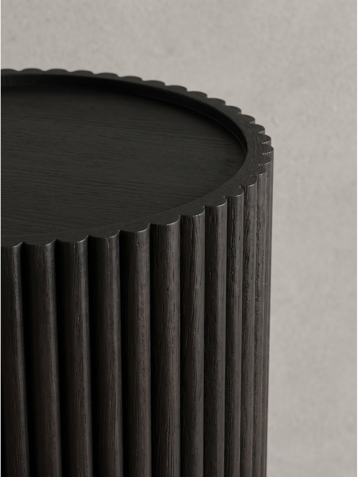 Detailansicht der schwarzen Säule aus Holz betont die architektonische Rillenstruktur_
