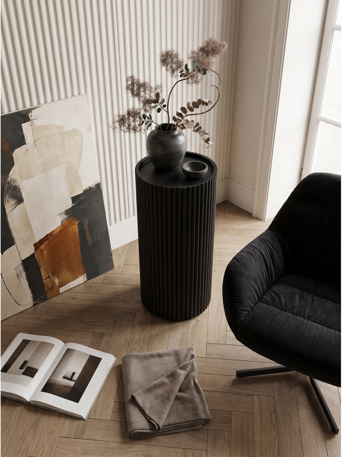Blick von oben auf die geriffelte Holzsäule in Schwarz neben einer hellen Wand mit einer organischen Keramikvase_