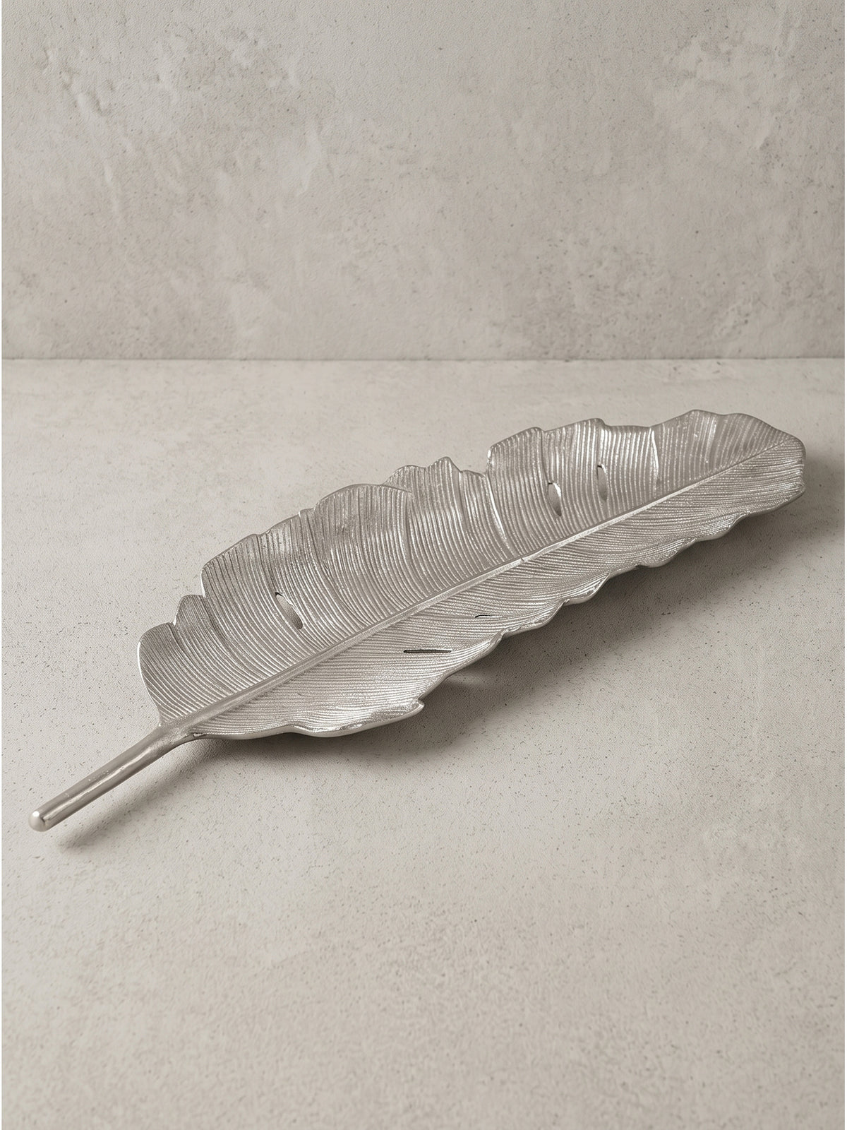 Dekoschale Blatt aus silbernem Aluminium freigestellt Ansicht von vorne zeigt die organische Struktur und den Stielgriff_
