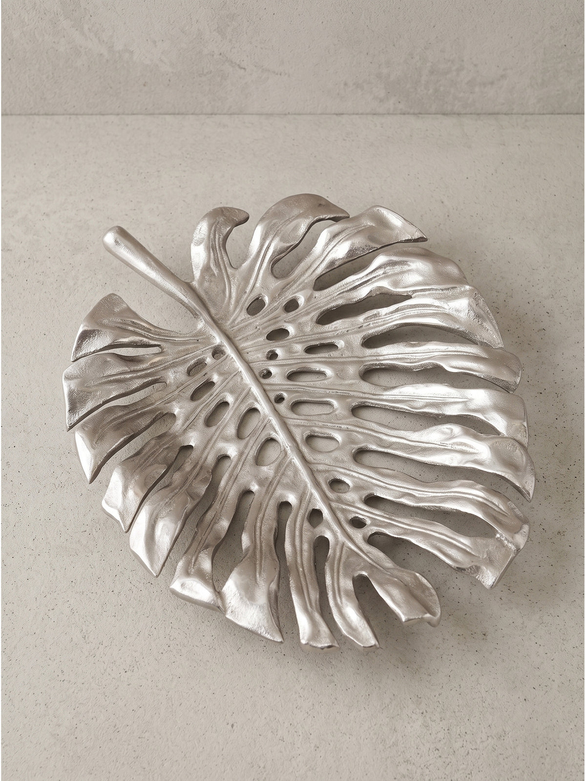 Handgefertigte Obstschale Metall Silber leicht schräg von der Seite fotografiert, um die flache und organische Linienführung zu zeigen.