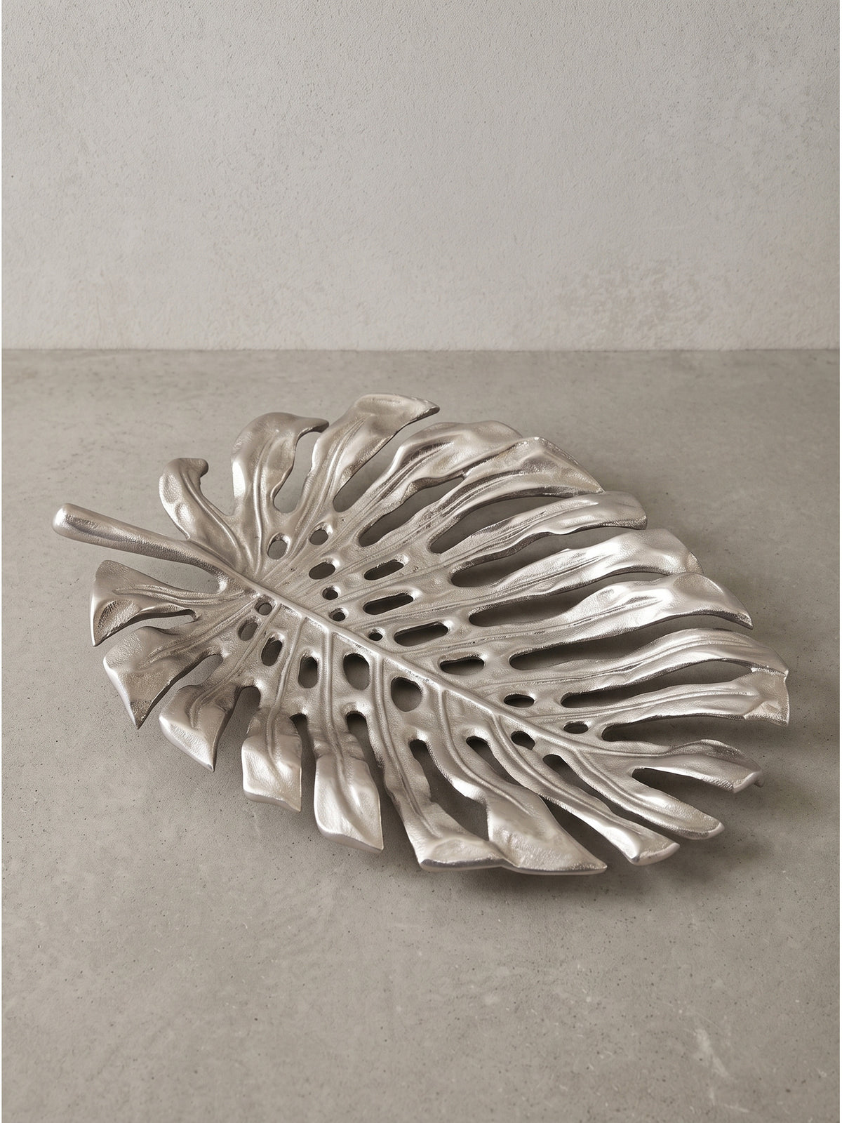 Glänzende Oberflächenstruktur der Deko Schale Silber mit detailliert ausgearbeiteten Rändern und Aussparungen im Material.