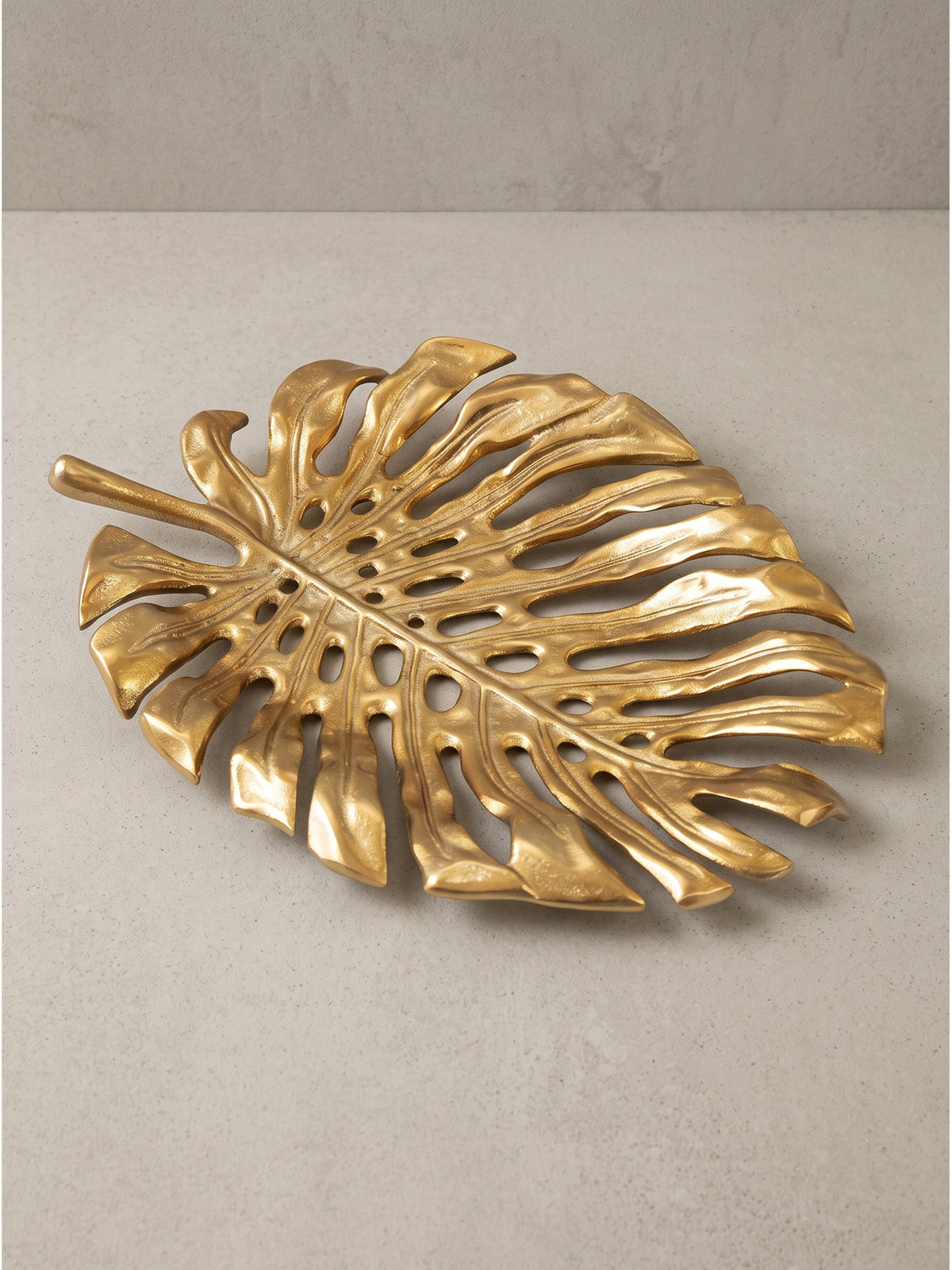 Dekoteller Blatt aus Aluminium komplett montiert in der Farbe Gold auf weißem Hintergrund leicht schräg von oben_