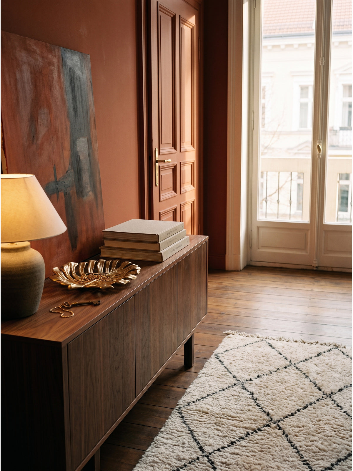Dekoschale Gold Aluminium 36x29x4 cm im Boho-Luxe Flur auf dunkelbraunem Sideboard vor einer terrakottafarbenen Akzentwand_