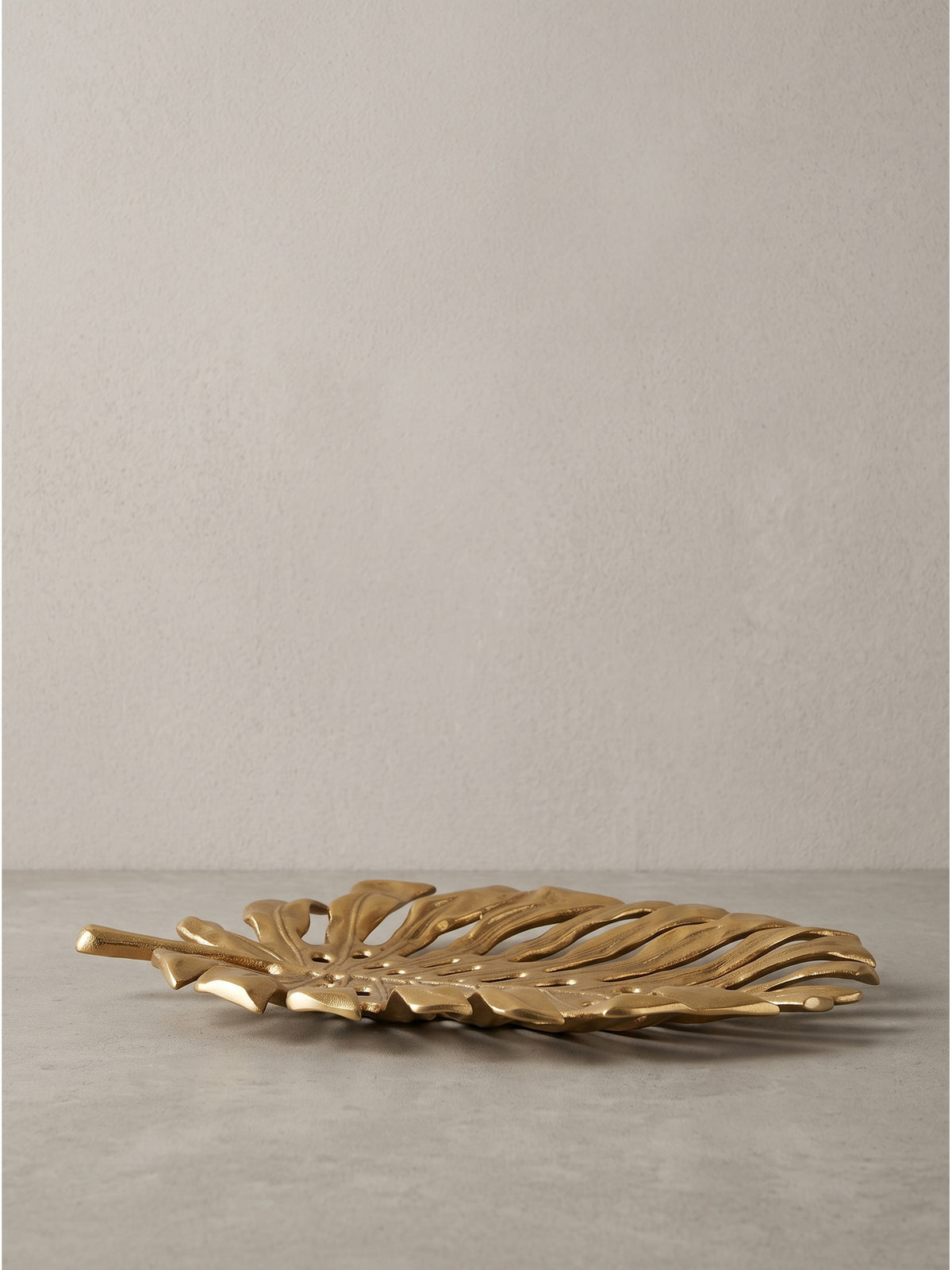 Seitenprofil der flachen Dekoschale Gold Aluminium 36cm mit detailreicher Blattader-Struktur auf hellem Hintergrund_