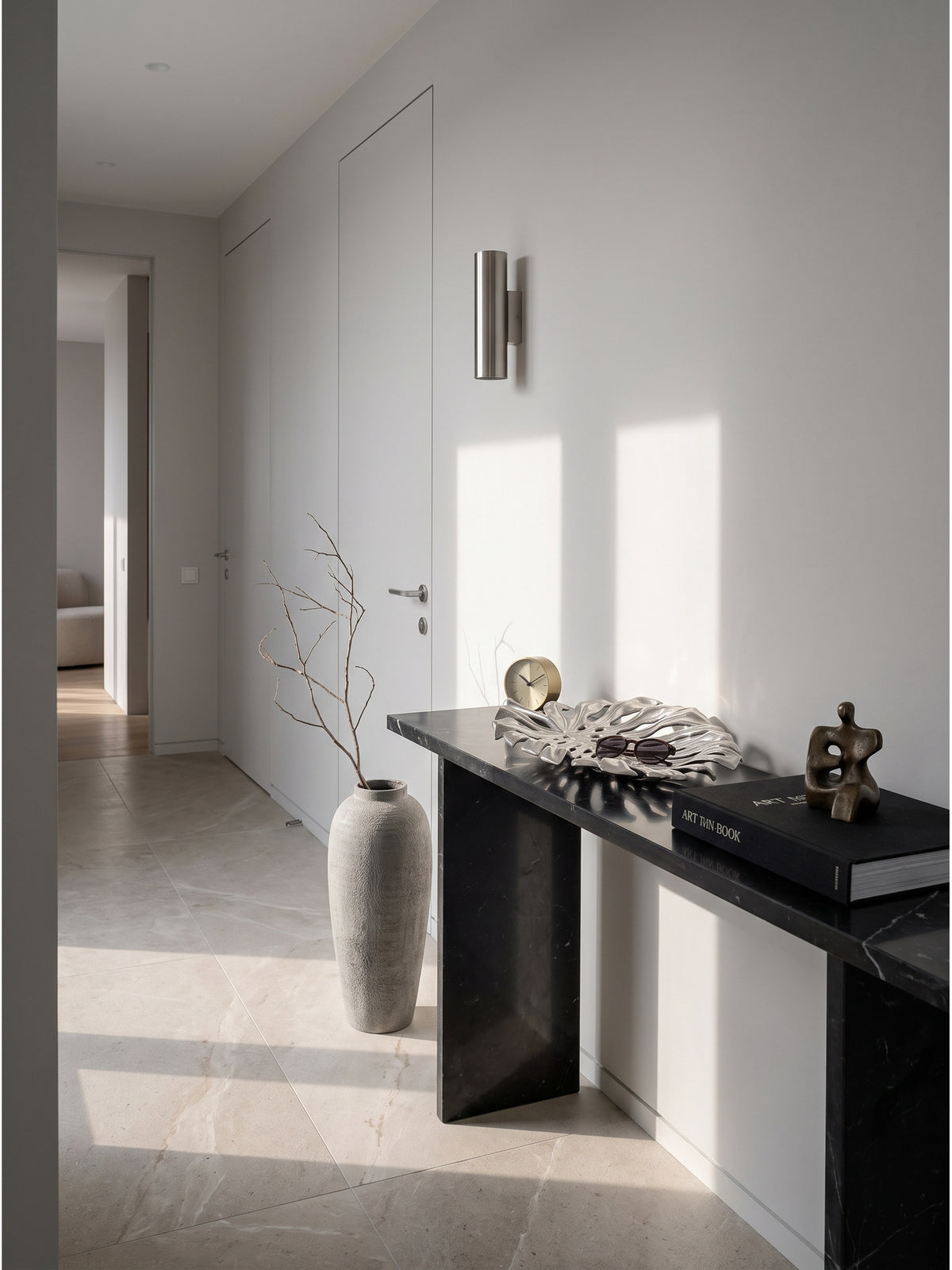 Große Dekoschale Silber aus massivem Aluminium 36x29 cm als eleganter Blickfang im minimalistischen Flur auf einer schwarzen Marmorkonsole._