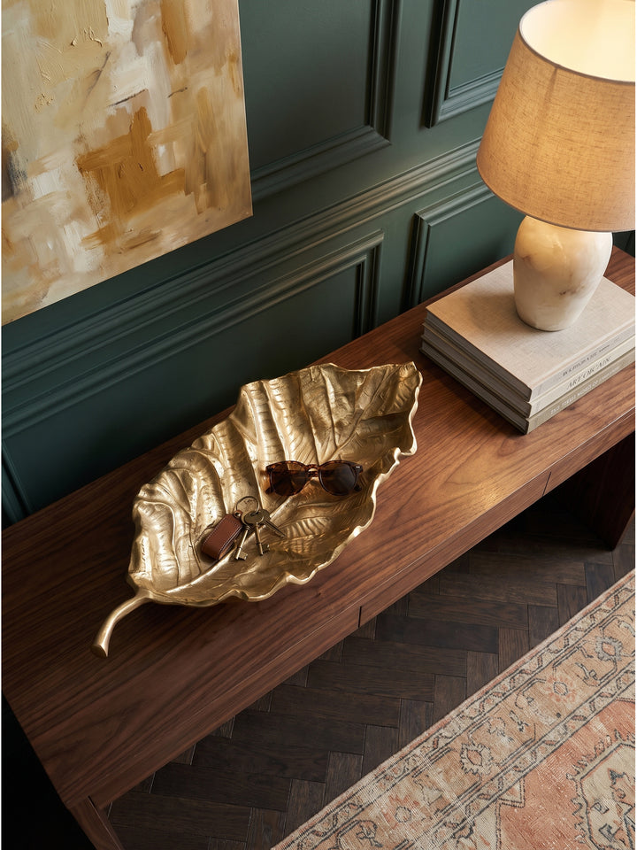 Draufsicht auf die 67 cm lange goldene Aluschale, die als edles Ablagetablett auf einem rustikalen Holztisch dient._