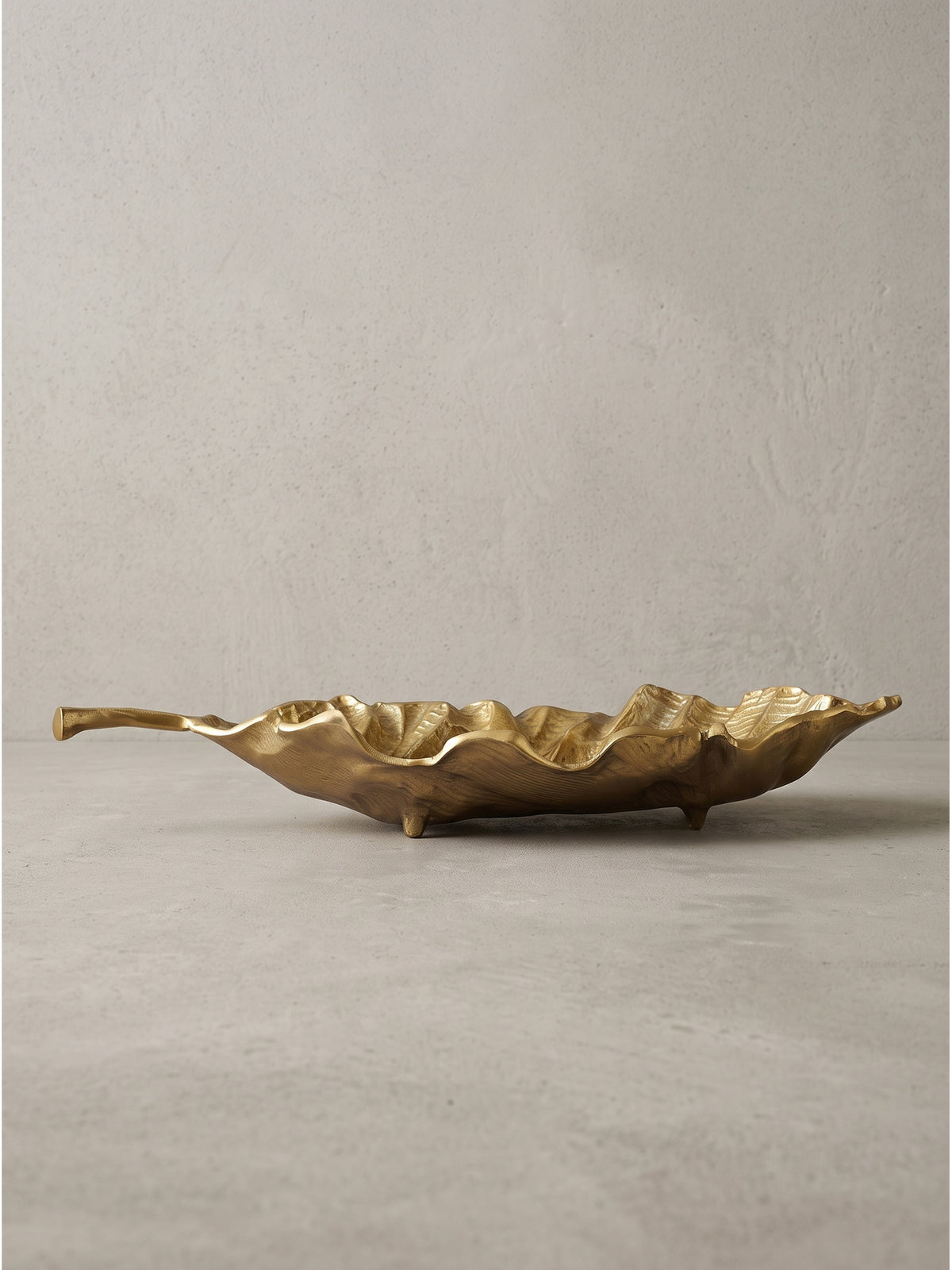 Seitenansicht der 11 cm hohen goldenen Aluminiumschale mit elegant geschwungenem Blattstiel als praktischem Griff.