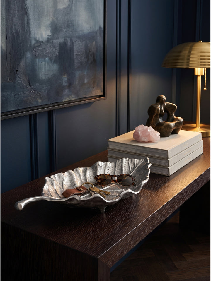 Silberne Dekoschale Blatt 67x27x11 cm genutzt als stilvolle Ablage für Schlüssel und Sonnenbrille auf einem Flur-Sideboard_
