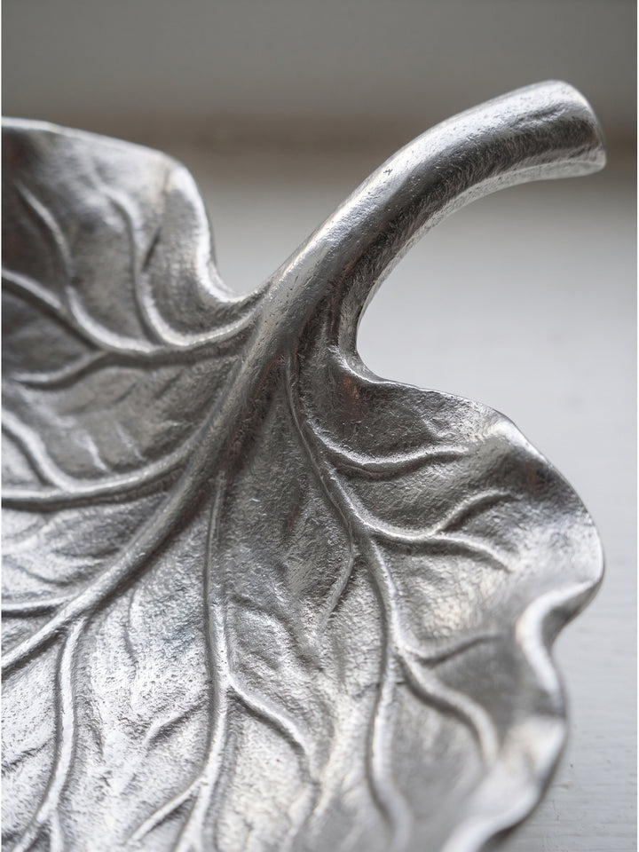 Nahaufnahme der organischen Blattstruktur der silbernen Aluminiumschale mit detaillierten Adern und glänzender Oberfläche_