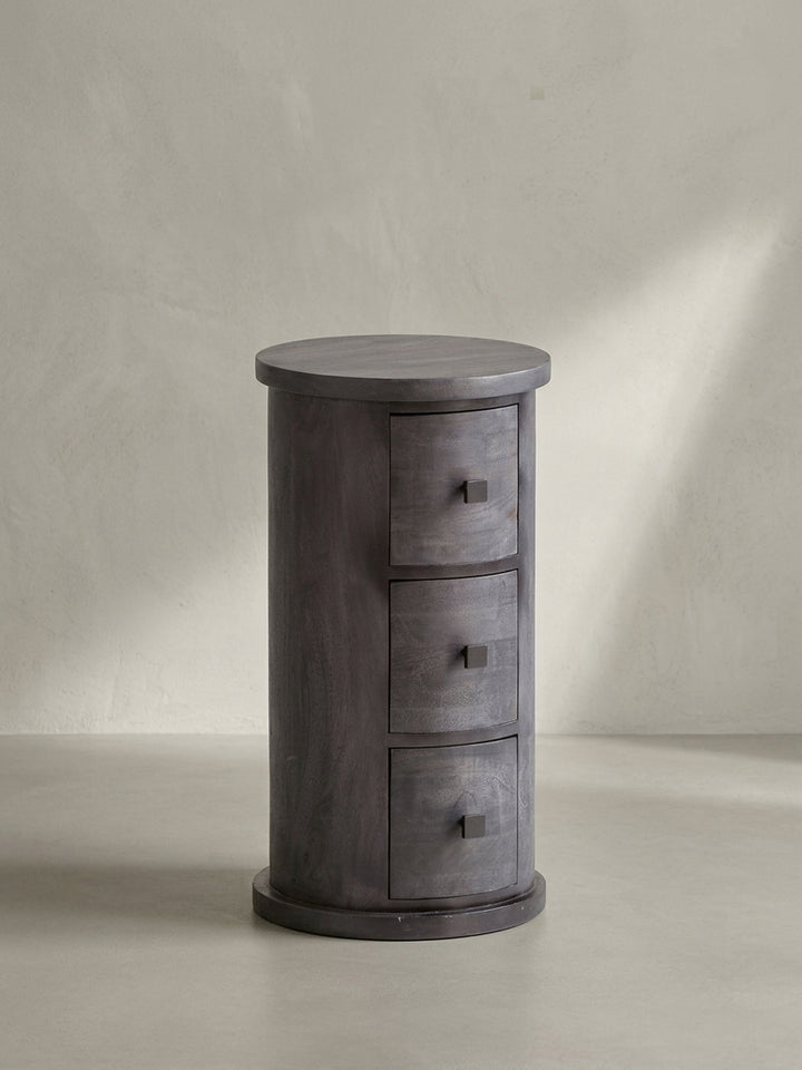 Gesamtansicht des Design-Beistellschranks aus Mangoholz, der durch seine runde Form und die schwarze Lackierung als zeitloses, massives Möbelstück wirkt._