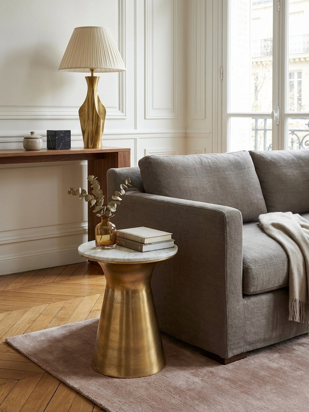 Runder Anstelltisch aus Marmor und Metall von oben gesehen, platziert auf einem gemusterten Teppich im Wohnzimmer, zeigt die 35 cm große Tischplatte in der Raumkomposition._