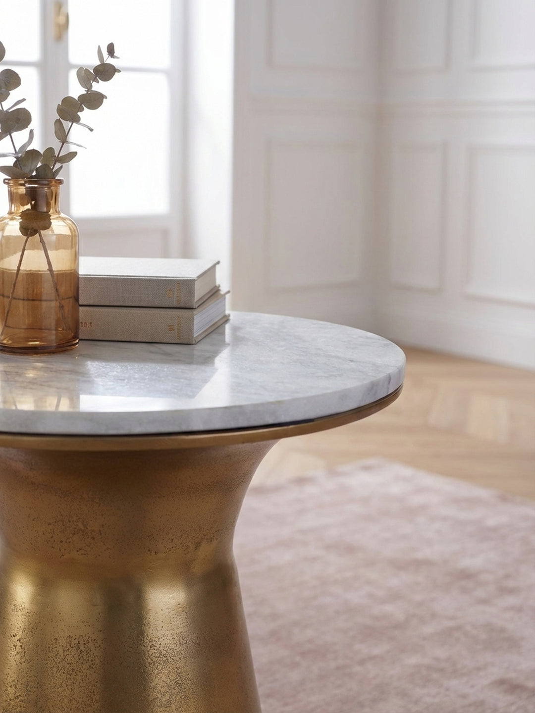 Nahaufnahme der gebürsteten Goldoberfläche des Metallgestells des Beistelltisches, die die handwerkliche Textur und den warmen Glanz des Materials hervorhebt._