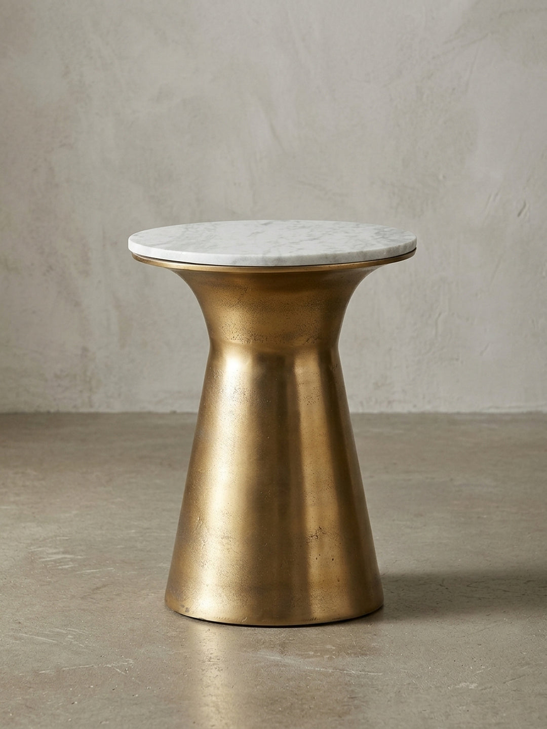 Moderner Beistelltisch 35x45 cm mit runder, weißer Echt-Marmorplatte und einem skulpturalen, goldfarbenen Aluminiumfuß, freigestellt auf weißem Hintergrund._