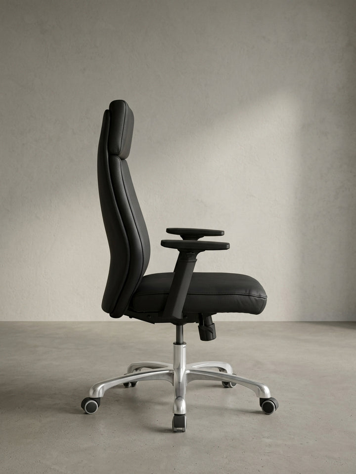 Rückansicht des eleganten Schreibtischstuhls aus Echtleder, die die klare Linienführung und die solide Mechanik unter dem Sitz präsentiert._