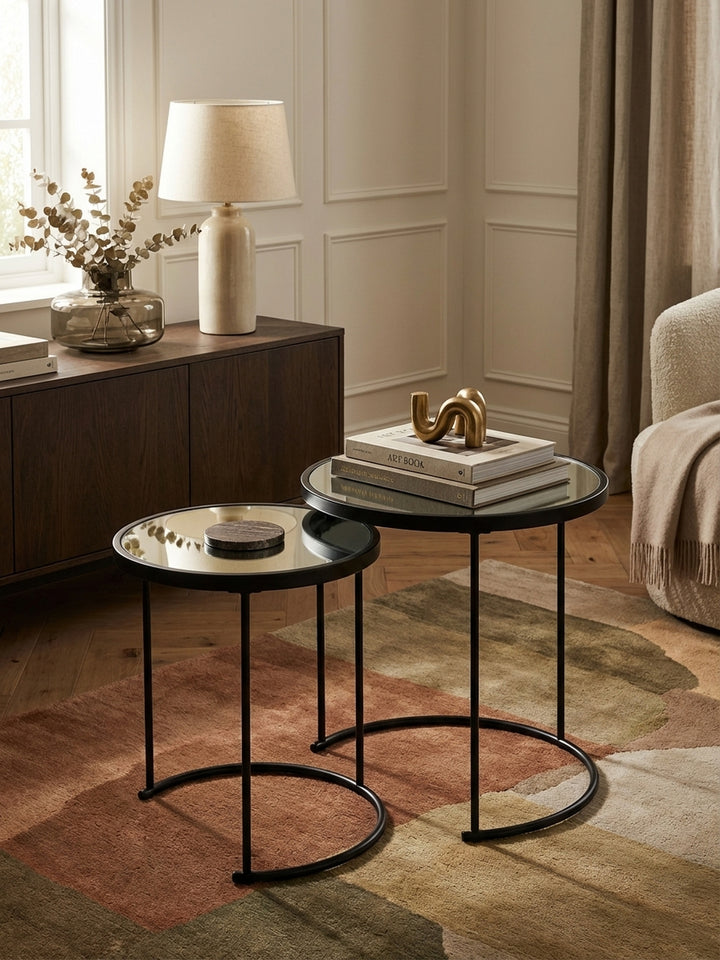 Runder Beistelltisch-Set von oben gesehen, das die verspiegelten Glasplatten und das platzsparende Nesting-Design im Zusammenspiel mit dem Wohnzimmer-Ambiente zeigt._