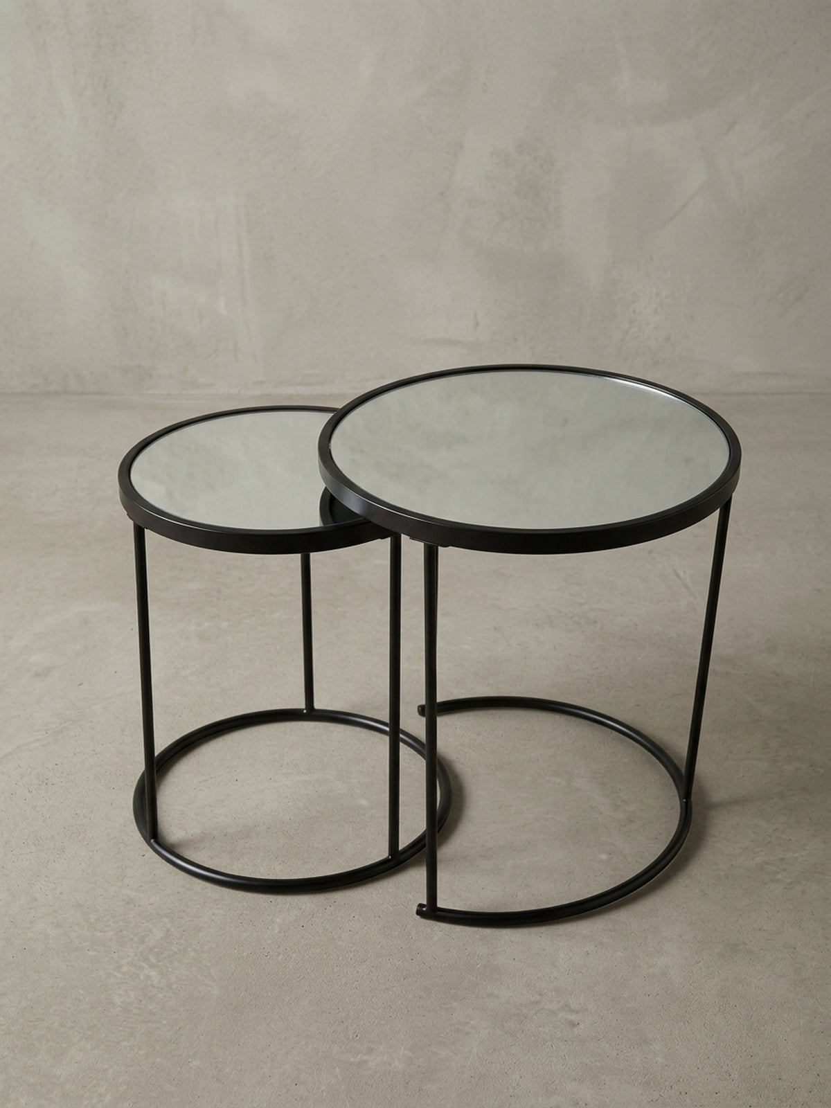 Zweiteiliger Couchtisch aus Metall und Spiegel in einer alternativen Perspektive, die das harmonische Zusammenspiel der unterschiedlichen Größen Ø 50 cm und Ø 42 cm betont._