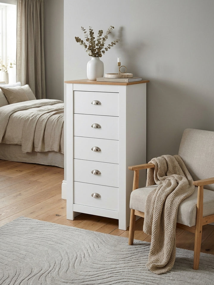 Die schmale Kommode in Weiß mit Eiche-Deckplatte steht in einem hellen Schlafzimmer und bietet mit fünf Schubladen eleganten Stauraum._