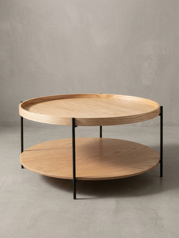 Sofatisch Eiche in 78 cm Durchmesser aus einer 3/4-Perspektive, die die filigrane Konstruktion der drei Stahlbeine hervorhebt._