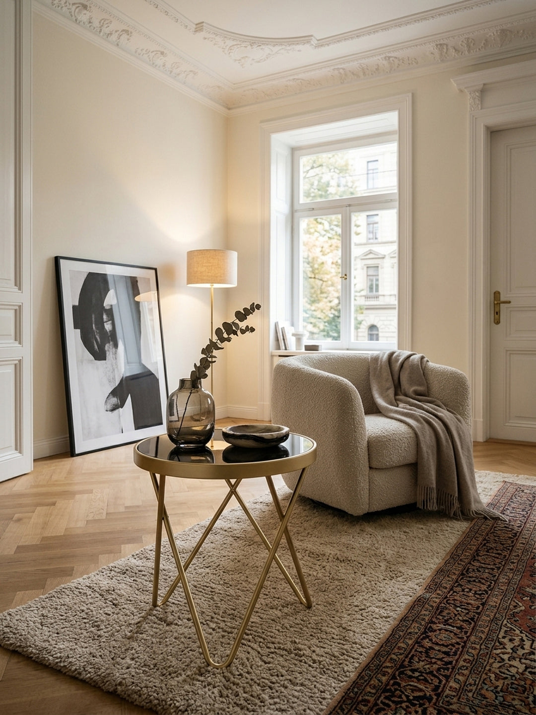 Eleganter Beistelltisch PARMA in Schwarz und Matt-Gold in einem luxuriösen Wohnzimmer. Der runde Glastisch mit filigranem Metallgestell ergänzt perfekt die helle, moderne Einrichtung._