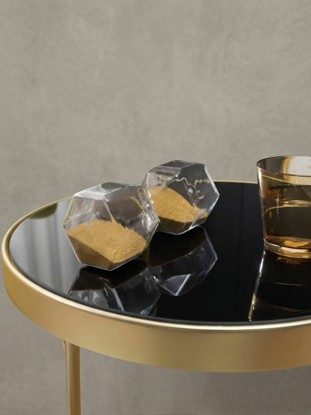 Geometrischer Couchtisch PARMA aus leicht erhöhter Perspektive. Die Kombination aus schwarzem Spiegelglas und dem glamourösen Goldrahmen bringt luxuriöses Flair ins heimische Wohnzimmer._